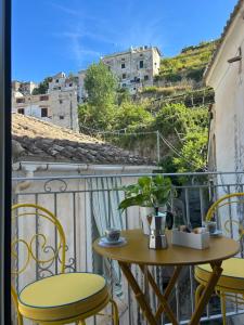 einen kleinen Tisch und Stühle auf einem Balkon mit Aussicht in der Unterkunft MIRAMA’ in Maiori