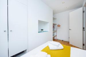 a bedroom with white cabinets and a yellow rug on a bed at One Bedroom Near Russell Square in London