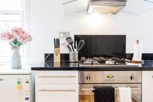 a kitchen with a stove top oven next to a counter at One Bedroom Near Russell Square in London