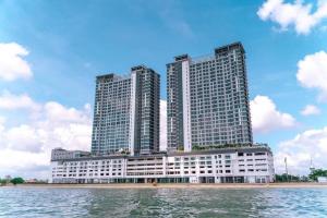 two tall buildings sitting next to a body of water at Brojat Suite Family City View @ Imperium Residence in Kuantan