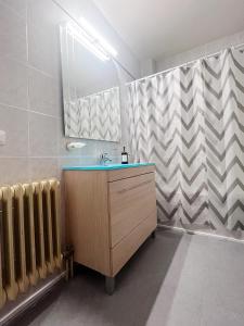 baño con lavabo, espejo y radiador en Casa Yolanda, en Ávila