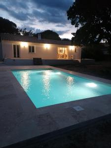 una piscina frente a una casa por la noche en Maison de vacances en Ventiseri