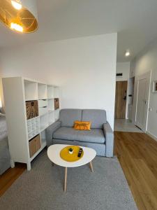 ein Wohnzimmer mit einem Sofa und einem Couchtisch in der Unterkunft R HOUSE - brand new apartments with patio and garage in Warschau