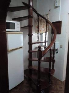 a spiral staircase in a kitchen with a microwave at Apartamentos das Avós- Wimari in Nazaré