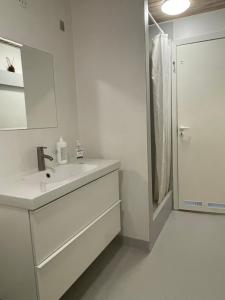 a white bathroom with a sink and a mirror at Landligt ophold på Midtgård in Vamdrup
