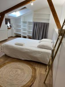 Petite maison de ville au calme في قلعة بري-كومت-روبير: غرفة نوم مع سرير وسجادة على الأرض