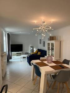 een eetkamer en een woonkamer met een tafel en een kroonluchter bij Petite maison de ville au calme in Brie-Comte-Robert
