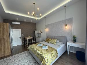 a bedroom with a bed and a table in it at Visit Debrecen Apartman in Debrecen