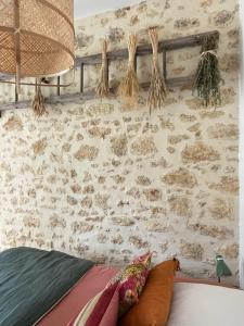 a bedroom with a stone wall and a bed with pillows at Loue charmante maison de vacances à 10 mns de Bellême (61) 