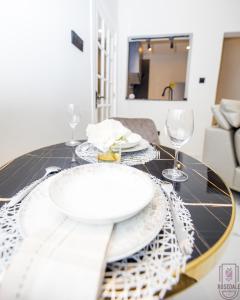a dining room table with a plate and wine glasses at Cozy 2 bedroom @the Rosedale in Accra