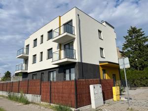 a white building with a red brick fence at R HOUSE - brand new apartments with patio and garage in Warsaw