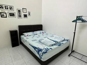a bedroom with a bed and a lamp in it at Guan Homestay Sungai Besar 大港民宿 in Sungai Besar