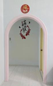 a hallway with an arch with a sign above it at Guan Homestay Sungai Besar 大港民宿 in Sungai Besar