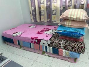 un piccolo letto con un piumone di benvenuto di Guan Homestay Sungai Besar 大港民宿 a Sungai Besar
