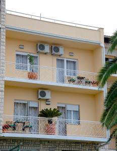 an apartment building with balconies and windows and palm trees at Luxe 3BR Apartment Split in Split