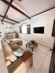 sala de estar con sofá y TV en Casa Tropical Arraial D' Ajuda, en Arraial d'Ajuda