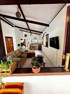 sala de estar con sofá y TV en Casa Tropical Arraial D' Ajuda, en Arraial d'Ajuda