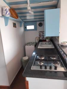 a kitchen with a stove and a sink at Terrazza sul mare attico "Alfeo e Aretusa" in Siracusa
