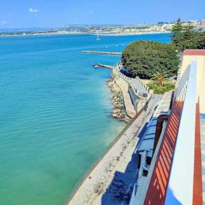 a view of the water from a building with benches at Terrazza sul mare attico "Alfeo e Aretusa" in Siracusa +5 photos