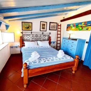 a bedroom with a bed and a blue dresser at Terrazza sul mare attico "Alfeo e Aretusa" in Siracusa