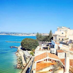 a view of a body of water with buildings at Terrazza sul mare attico "Alfeo e Aretusa" in Siracusa