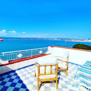 two chairs sitting on a balcony overlooking the ocean at Terrazza sul mare attico "Alfeo e Aretusa" in Siracusa