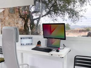 a desk with a laptop computer on top of it at El Coso Lodge & Workation in Zalamea la Real