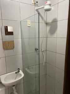 uma casa de banho com uma cabina de duche em vidro e um lavatório. em Villa Nevada Hostel em Bananeiras