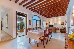 a dining room with a table and chairs and a kitchen at Sa Marilyn - Can Campins in Sa Pobla