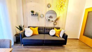 a couch with yellow and white pillows in a living room at Ferienwohnungen Krüger ''Apartment Finn" in Michelstadt