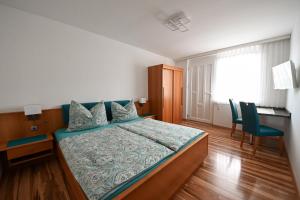 A bed or beds in a room at Gästehaus zum See