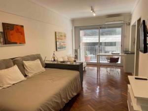 1 dormitorio con 1 cama y sala de estar en Studio Palermo Hermoso Con Balcon en Buenos Aires