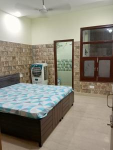 - une chambre avec un grand lit et une chaise bleue dans l'établissement Hare Krishna Flat, à Kharar