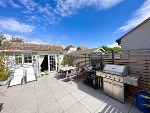 a patio with a grill and a table and chairs at Beautiful 1-Bed Cabin in Hayling Island in South Hayling