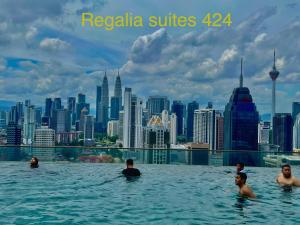 um grupo de pessoas a nadar na piscina de beiral infinito nas suites reptilia em Regalia suites 424 em Kuala Lumpur