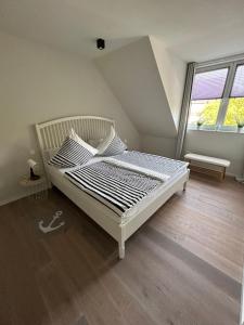 ein Schlafzimmer mit einem weißen Bett in einem Zimmer in der Unterkunft Außergewöhnlich Ferienwohnung im Villenviertel in Wilhelmshaven