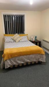 a bedroom with a large bed with a yellow blanket at Leicester City Center - Sauna Pool Gym in Leicester