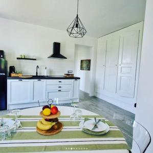 una cocina con una mesa de cristal con fruta. en LA CASA SULLA COLLINA, en Cocconato