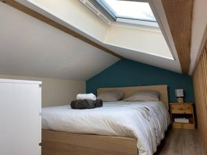 a bedroom with a large bed with a skylight at Appartement climatisé avec terrasse in Cours la Ville