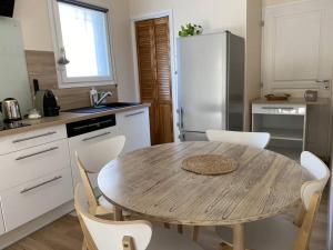 a kitchen with a wooden table and white appliances at Appartement climatisé avec terrasse in Cours la Ville