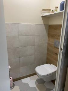 a bathroom with a white toilet in a room at Appartement climatisé avec terrasse in Cours la Ville