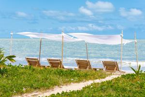 - un groupe de chaises sur une plage donnant sur l'océan dans l'établissement Casa Mandala Corumbau, à Corumbau