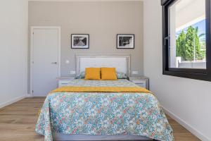 a white bedroom with a bed with a yellow pillow at Villa MaJa Albir in Albir +30 photos
