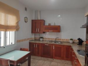 ラ・プエブラ・デ・カサジャにあるCasa Almazara con aparcamientoのキッチン(木製キャビネット、テーブル、シンク付)