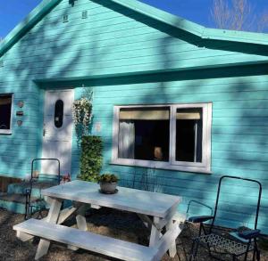 a picnic table in front of a blue house at The Croft Accommodation in Gamrie