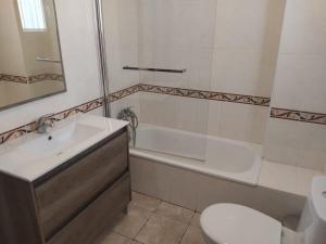 a bathroom with a sink and a tub and a toilet at Casa Almazara in La Puebla de Cazalla