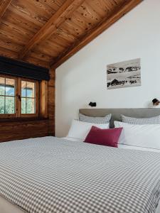 um quarto com uma cama com almofadas brancas e roxas em Chalet Alpin mit privatem Whirlpool und Sauna em Bayrischzell