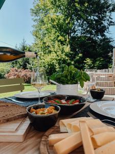 uma mesa com comida e uma garrafa de vinho e queijo em Chalet Alpin mit privatem Whirlpool und Sauna em Bayrischzell