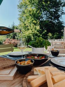 un tavolo con cibo e una bottiglia di vino e formaggio di Chalet Alpin mit privatem Whirlpool und Sauna a Bayrischzell