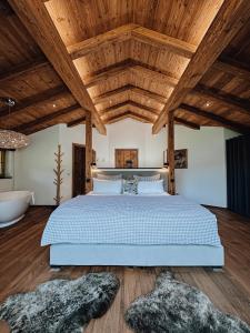 una camera con letto e soffitto in legno di Chalet Alpin mit privatem Whirlpool und Sauna a Bayrischzell